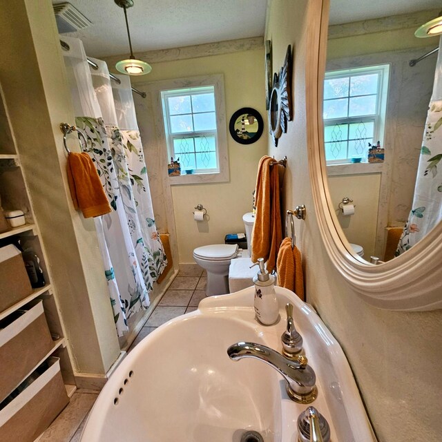 1239 Indian Hill Blvd, Livingston, TX 77351 - full bathroom featuring toilet, healthy amount of natural light, shower / bath combo, and tile patterned floors