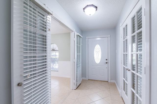 5214 Meadow Crest St, La Porte, TX 77571 - foyer featuring light tile patterned flooring, a textured ceiling, and wainscoting