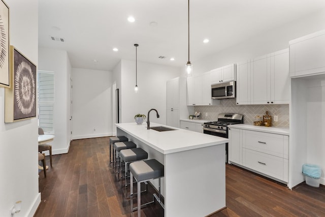 2022 Thonig Rd Unit C, Houston, TX 77055 - kitchen with a sink, stainless steel appliances, dark wood finished floors, decorative backsplash, and white cabinets