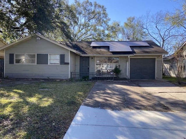 5810 Belmark St, Houston, TX 77033 - ranch-style house featuring solar panels, an attached garage, driveway, and a front lawn