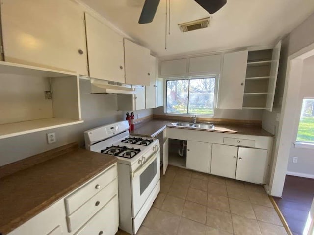 5810 Belmark St, Houston, TX 77033 - kitchen featuring white range with gas cooktop, under cabinet range hood, a sink, a ceiling fan, and white cabinetry
