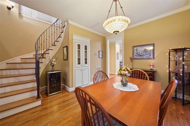 606 E 27th St, Houston, TX 77008 - dining area with stairs, wood finished floors, crown molding, beverage cooler, and baseboards