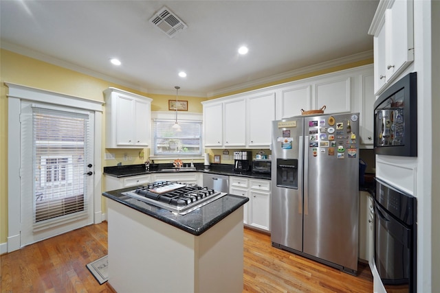 606 E 27th St, Houston, TX 77008 - kitchen featuring black appliances, white cabinetry, crown molding, a center island, and pendant lighting