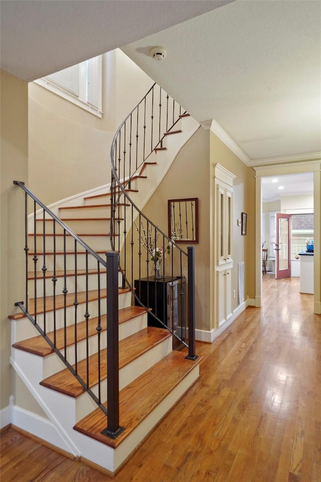 606 E 27th St, Houston, TX 77008 - stairs featuring wood finished floors, baseboards, and ornamental molding