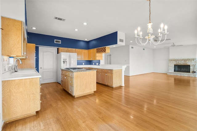 1022 Darcy St, Galveston, TX 77554 - kitchen with a sink, a chandelier, stainless steel gas cooktop, light wood-style flooring, and a kitchen island