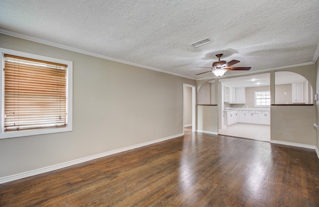 2020 Vince St, Pasadena, TX 77502 - unfurnished living room featuring dark wood-type flooring, ceiling fan, baseboards, crown molding, and a textured ceiling