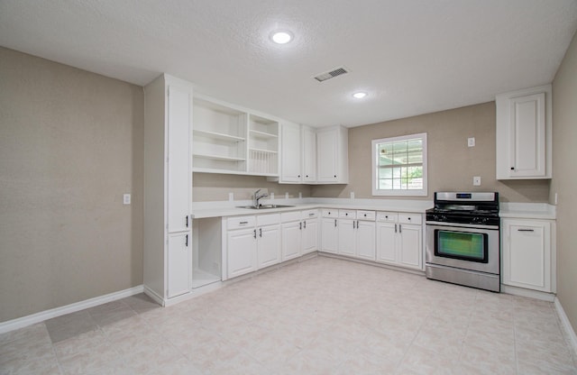 2020 Vince St, Pasadena, TX 77502 - kitchen with stainless steel gas stove, a sink, light countertops, white cabinets, and baseboards
