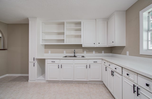 2020 Vince St, Pasadena, TX 77502 - kitchen featuring a sink, light countertops, open shelves, white cabinetry, and light tile patterned flooring