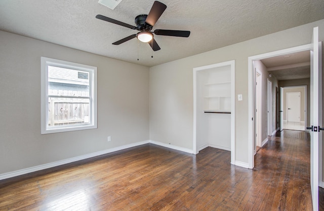 2020 Vince St, Pasadena, TX 77502 - unfurnished room with dark wood-style floors, a textured ceiling, baseboards, a ceiling fan, and built in shelves