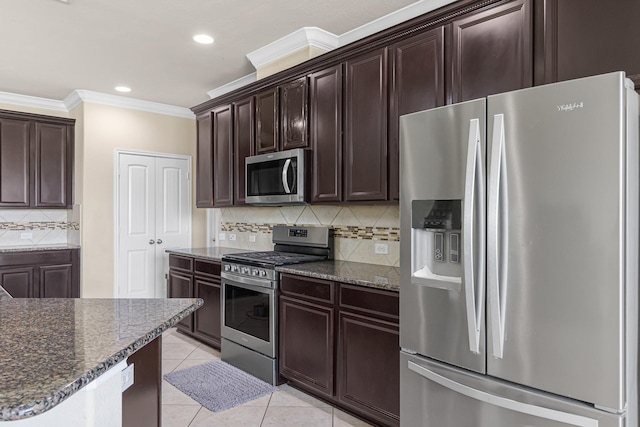 26010 Pagemill Ln, Richmond, TX 77406 - kitchen with stainless steel appliances, crown molding, tasteful backsplash, dark stone countertops, and light tile patterned floors