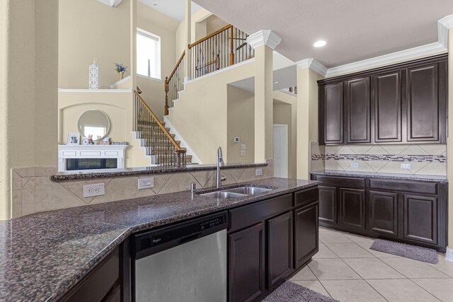 26010 Pagemill Ln, Richmond, TX 77406 - kitchen featuring stainless steel dishwasher, a sink, tasteful backsplash, dark stone counters, and light tile patterned flooring