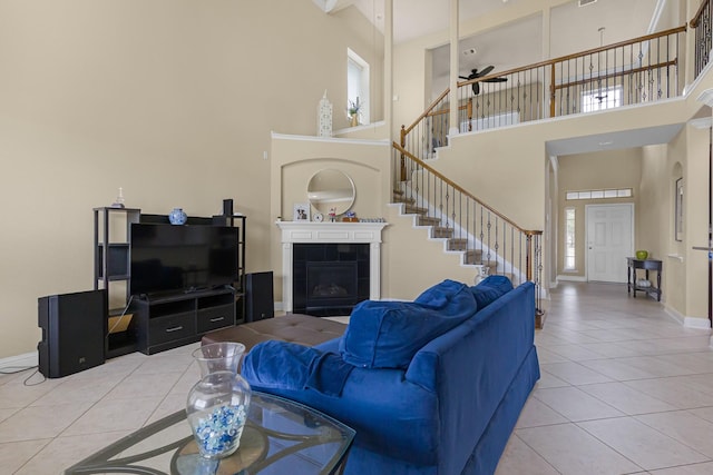 26010 Pagemill Ln, Richmond, TX 77406 - living room with tile patterned floors, stairway, a towering ceiling, baseboards, and a tiled fireplace