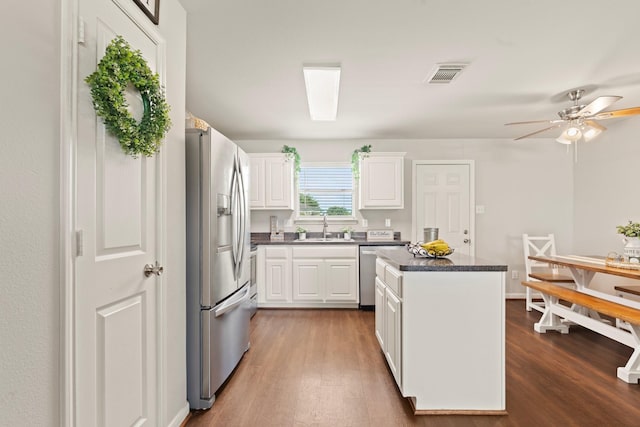 4423 Olive Field Ct, Richmond, TX 77469 - kitchen featuring stainless steel appliances, a sink, dark wood finished floors, a kitchen island, and dark countertops