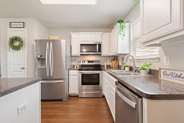 4423 Olive Field Ct, Richmond, TX 77469 - kitchen with stainless steel appliances, a sink, white cabinetry, and dark countertops