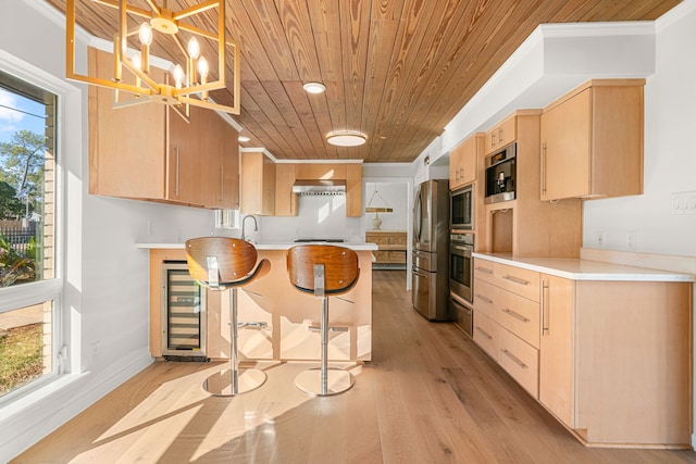 5747 Jackwood St, Houston, TX 77096 - kitchen with wood ceiling, light brown cabinetry, stainless steel appliances, a peninsula, and wall chimney range hood