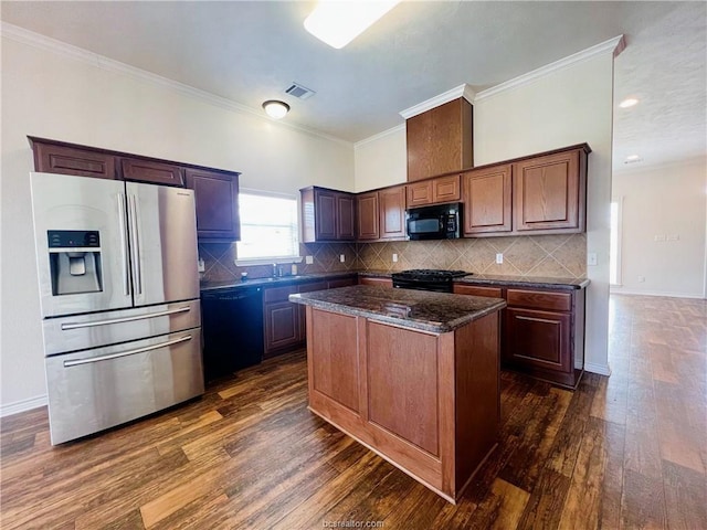 1027 Emerald Dove Ave, College Station, TX 77845 - kitchen featuring black appliances, dark wood finished floors, a center island, backsplash, and ornamental molding