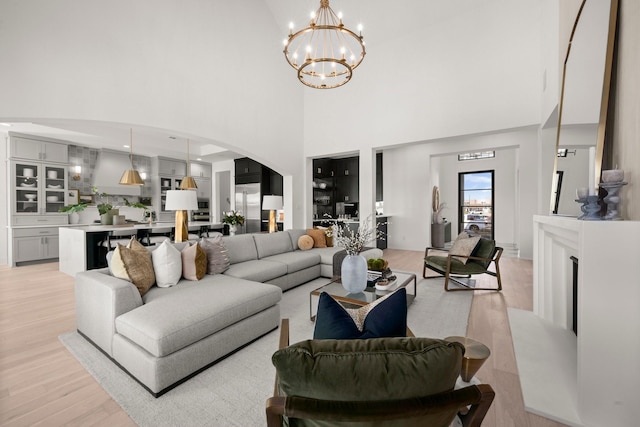 1902 Kessler Point Pl, Katy, TX 77493 - living room featuring light wood finished floors, a chandelier, a high ceiling, and arched walkways