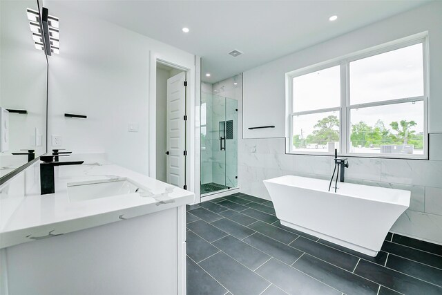1913 Hoskins Dr Unit F, Houston, TX 77080 - bathroom with tile walls, double vanity, a stall shower, a soaking tub, and recessed lighting