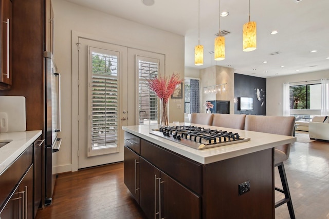 4129 Dickson St, Houston, TX 77007 - kitchen featuring stainless steel gas stovetop, a breakfast bar area, dark wood-style flooring, open floor plan, and light countertops