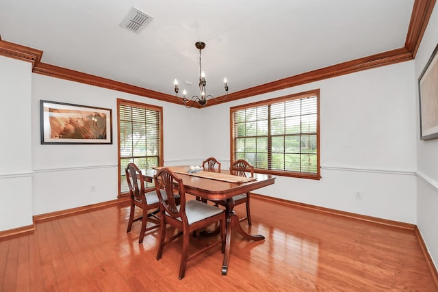 1207 W Edgewood Dr, Friendswood, TX 77546 - dining room featuring crown molding, a chandelier, wood finished floors, plenty of natural light, and baseboards