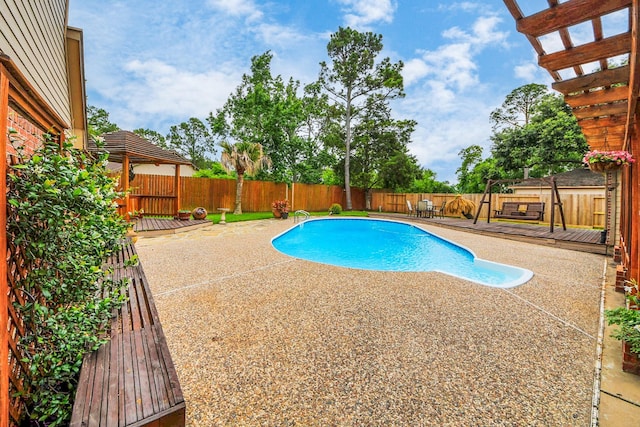 1207 W Edgewood Dr, Friendswood, TX 77546 - view of swimming pool with a fenced backyard, a patio, and a wooden deck
