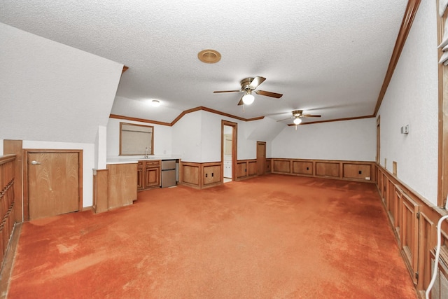 1207 W Edgewood Dr, Friendswood, TX 77546 - unfurnished living room featuring wainscoting, a ceiling fan, a textured ceiling, a sink, and light carpet