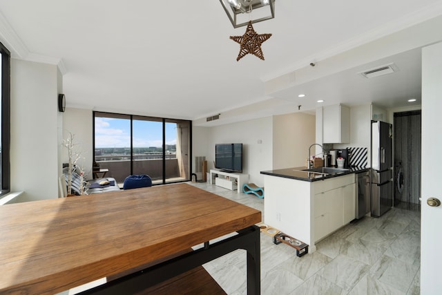3525 Sage Rd Unit 1104, Houston, TX 77056 - kitchen featuring a sink, freestanding refrigerator, white cabinetry, dark countertops, and ornamental molding