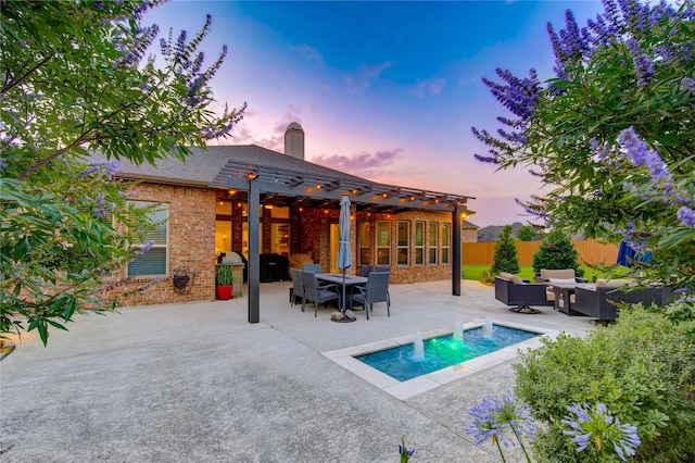 28907 Copper Break Ct, Katy, TX 77494 - back of house at dusk with outdoor lounge area, a patio area, a chimney, and brick siding