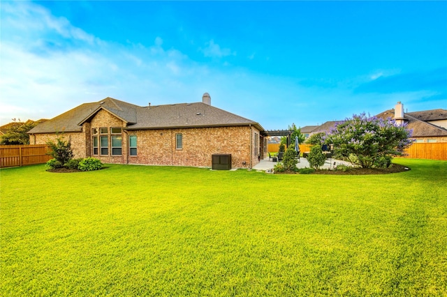 28907 Copper Break Ct, Katy, TX 77494 - rear view of property featuring brick siding, central AC, a chimney, and a shingled roof