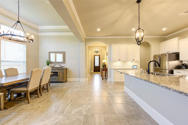 28907 Copper Break Ct, Katy, TX 77494 - kitchen with arched walkways, a chandelier, freestanding refrigerator, decorative backsplash, and recessed lighting