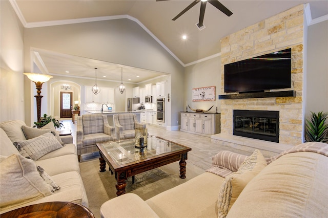 28907 Copper Break Ct, Katy, TX 77494 - living room featuring a ceiling fan, a stone fireplace, ornamental molding, recessed lighting, and arched walkways