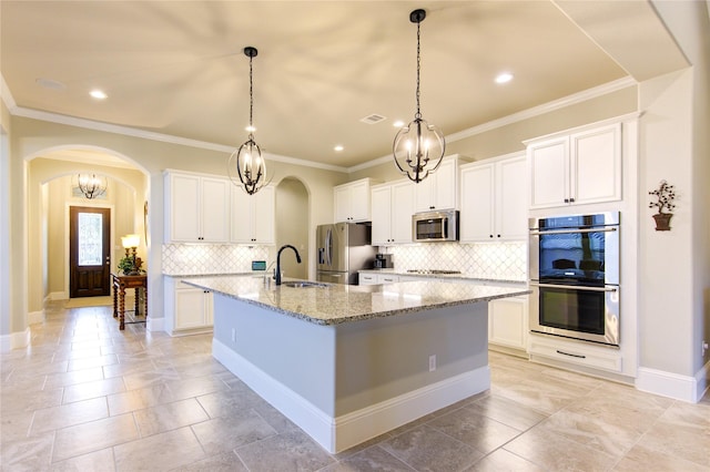 28907 Copper Break Ct, Katy, TX 77494 - kitchen featuring stainless steel appliances, arched walkways, a sink, a large island, and backsplash