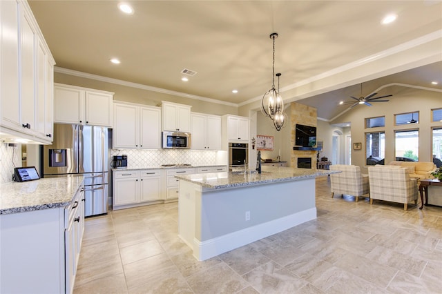 28907 Copper Break Ct, Katy, TX 77494 - kitchen with appliances with stainless steel finishes, open floor plan, a ceiling fan, white cabinetry, and decorative backsplash