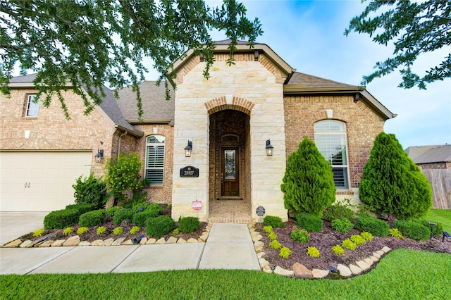 28907 Copper Break Ct, Katy, TX 77494 - french country inspired facade with a shingled roof, brick siding, stone siding, and driveway