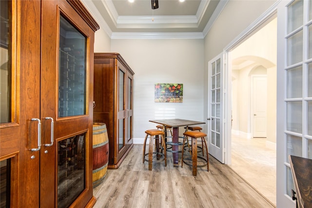 28907 Copper Break Ct, Katy, TX 77494 - dining space with arched walkways, french doors, light wood-style flooring, a raised ceiling, and baseboards