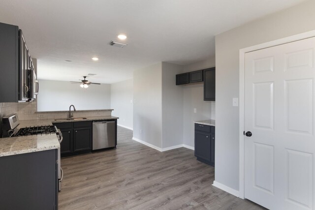5903 Bonners Park Ct, Katy, TX 77449 - kitchen with appliances with stainless steel finishes, a sink, a ceiling fan, baseboards, and decorative backsplash
