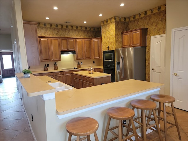 3501 Carson Ct, Pearland, TX 77584 - kitchen featuring black appliances, light tile patterned floors, wallpapered walls, a center island, and a sink