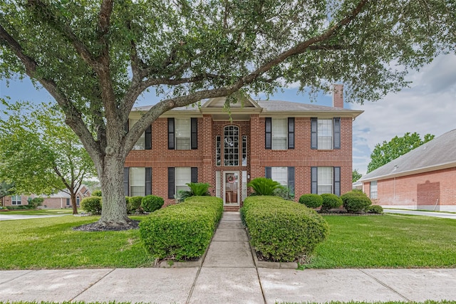 11203 Chestnut Woods Trl, Houston, TX 77065 - view of front facade with a chimney, a front yard, and brick siding
