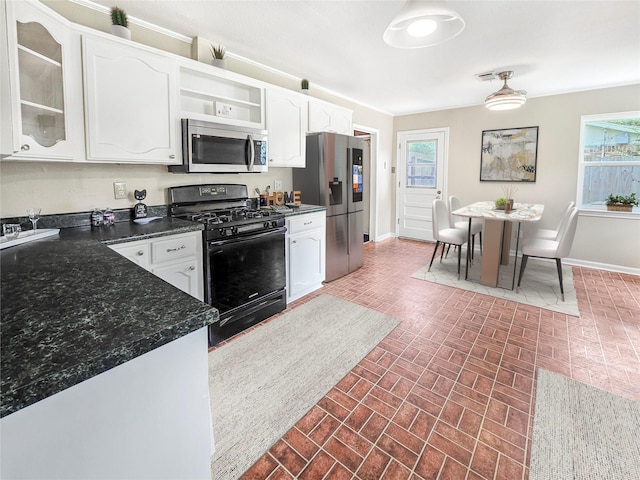 723 Pas Trl, Houston, TX 77336 - kitchen featuring appliances with stainless steel finishes, brick patterned flooring, white cabinetry, and plenty of natural light
