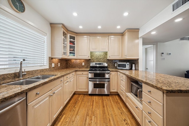 2415 Avalon Pl, Houston, TX 77019 - kitchen featuring appliances with stainless steel finishes, a sink, a peninsula, light brown cabinetry, and recessed lighting