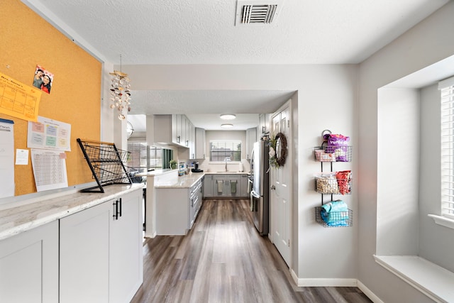 3808 Cottonwood Dr, La Porte, TX 77571 - kitchen with freestanding refrigerator, wood finished floors, a textured ceiling, a sink, and baseboards