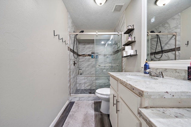 3808 Cottonwood Dr, La Porte, TX 77571 - full bathroom featuring toilet, vanity, a textured ceiling, a marble finish shower, and wood finished floors
