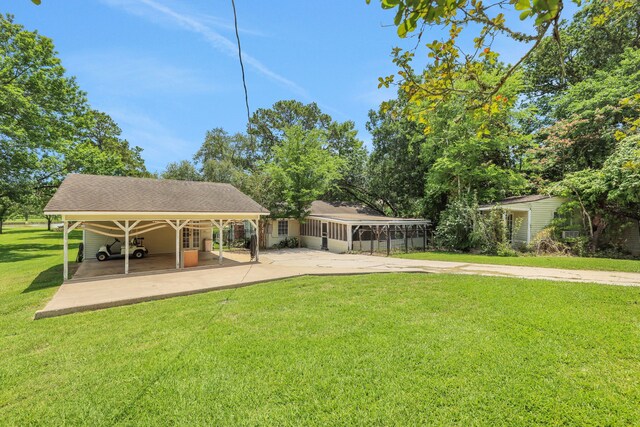 151 Lakeview Cir, Coldspring, TX 77331 - view of green lawn featuring a carport and concrete driveway