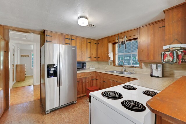151 Lakeview Cir, Coldspring, TX 77331 - kitchen with a sink, appliances with stainless steel finishes, light wood finished floors, tasteful backsplash, and light countertops