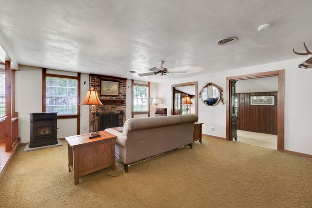151 Lakeview Cir, Coldspring, TX 77331 - living room with light carpet, a wood stove, baseboards, ceiling fan, and a brick fireplace