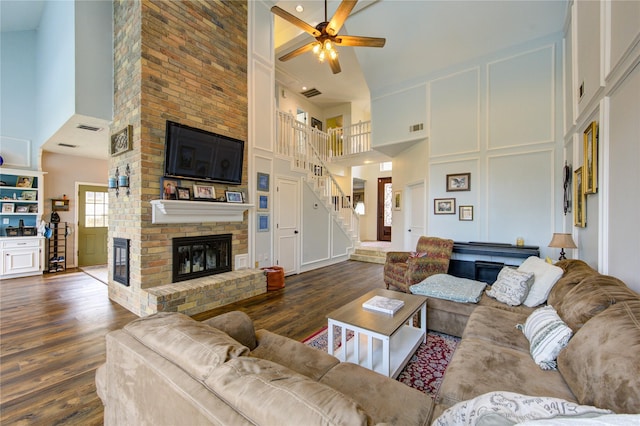 12306 Heatherwick Dr, Cypress, TX 77429 - living room featuring high vaulted ceiling, a fireplace, wood finished floors, ceiling fan, and stairway