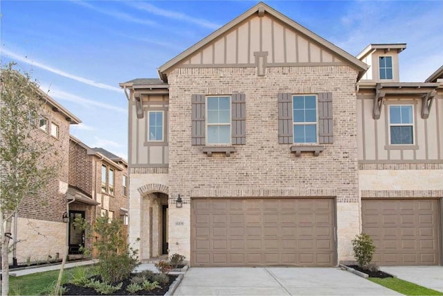 11231 Buchanan Coves Ln, Cypress, TX 77433 - tudor-style house with board and batten siding, brick siding, a garage, and concrete driveway