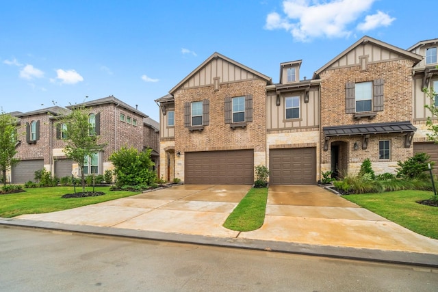 11231 Buchanan Coves Ln, Cypress, TX 77433 - view of front of house featuring board and batten siding, concrete driveway, an attached garage, brick siding, and a front lawn