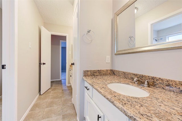 2311 Pepperweed Dr, Houston, TX 77084 - bathroom with vanity, baseboards, a textured ceiling, and tile patterned flooring