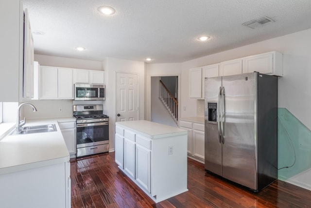10107 Sands Trail Ct, Houston, TX 77064 - kitchen with appliances with stainless steel finishes, a sink, dark wood-style floors, a kitchen island, and recessed lighting